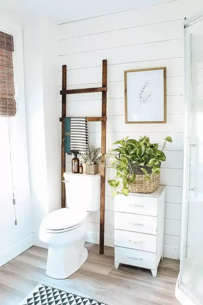 Bamboo over the toilet storage rack with styled shelves in a small rental bathroom