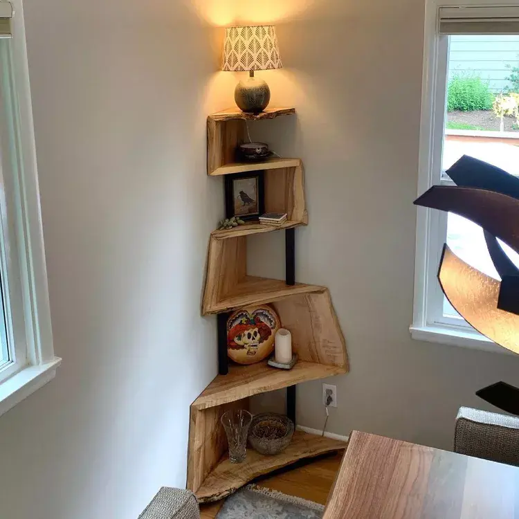 Small bedroom corner shelves holding plants books and decorative storage
