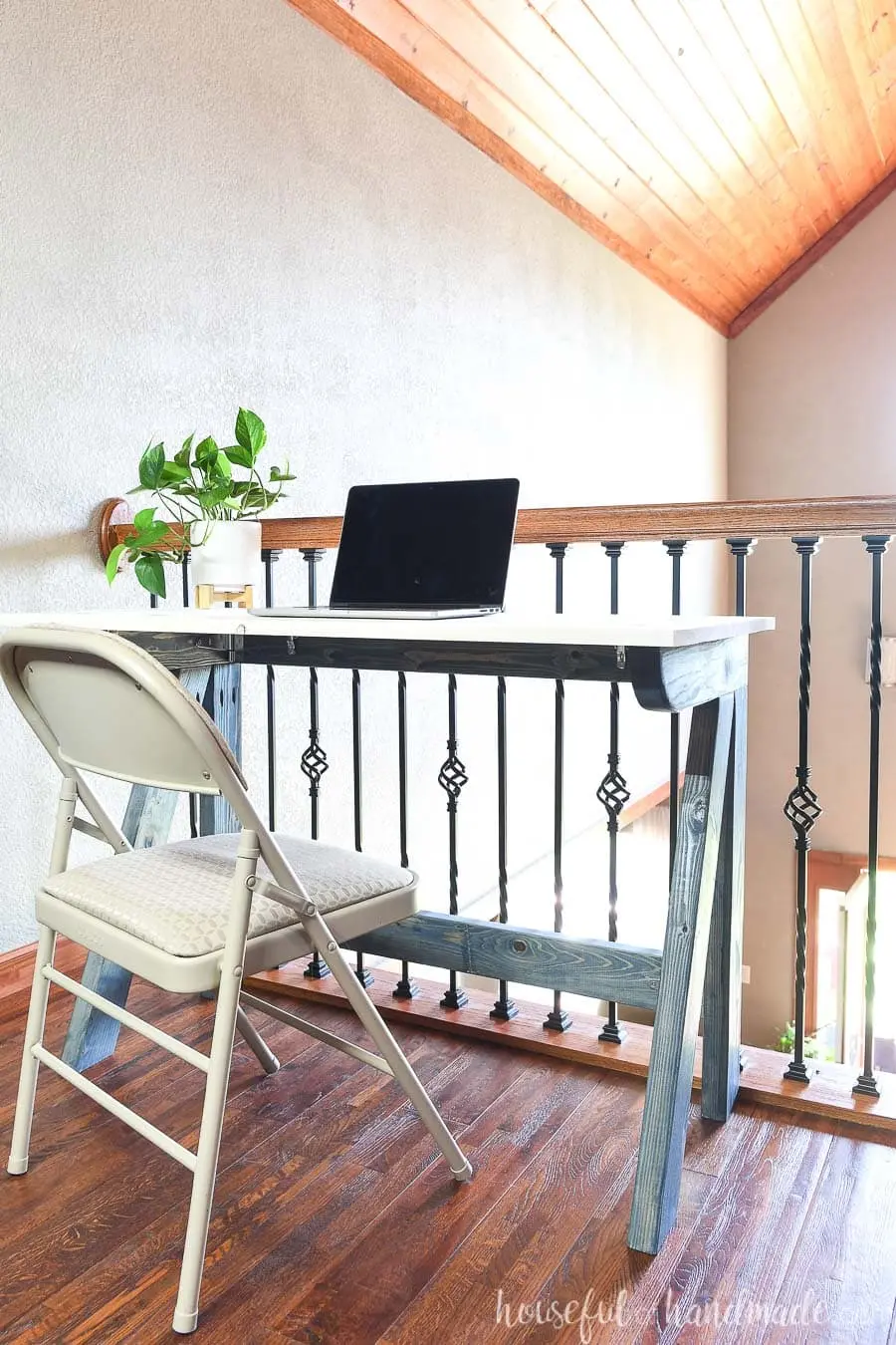 Wall mounted folding desk in a small bedroom creating a workspace that disappears