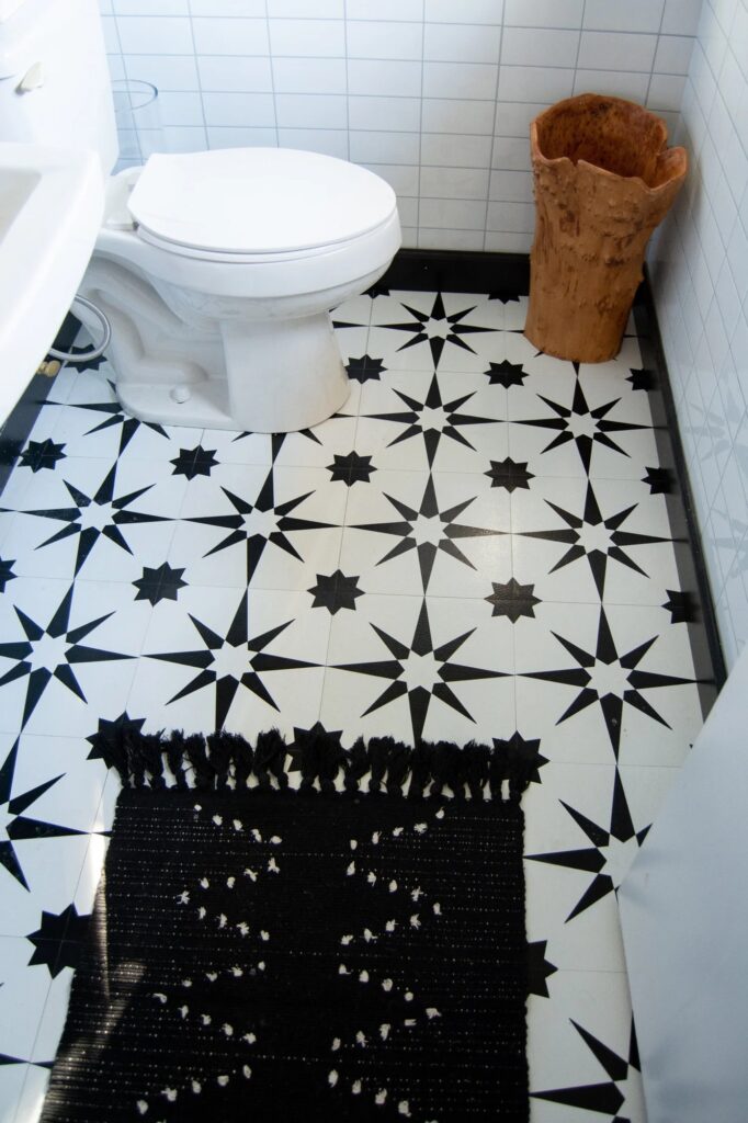 Bathroom floor with peel and stick tiles in black and white pattern