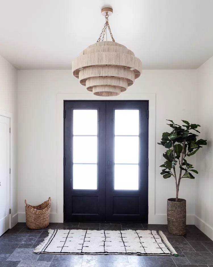 Woven rattan chandelier in a warm styled entryway with natural light