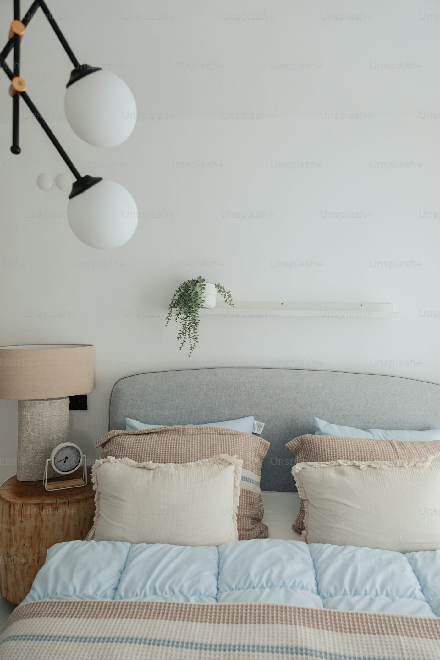 One bedroom apartment with styled bed layered neutral bedding and warm ambient lighting
