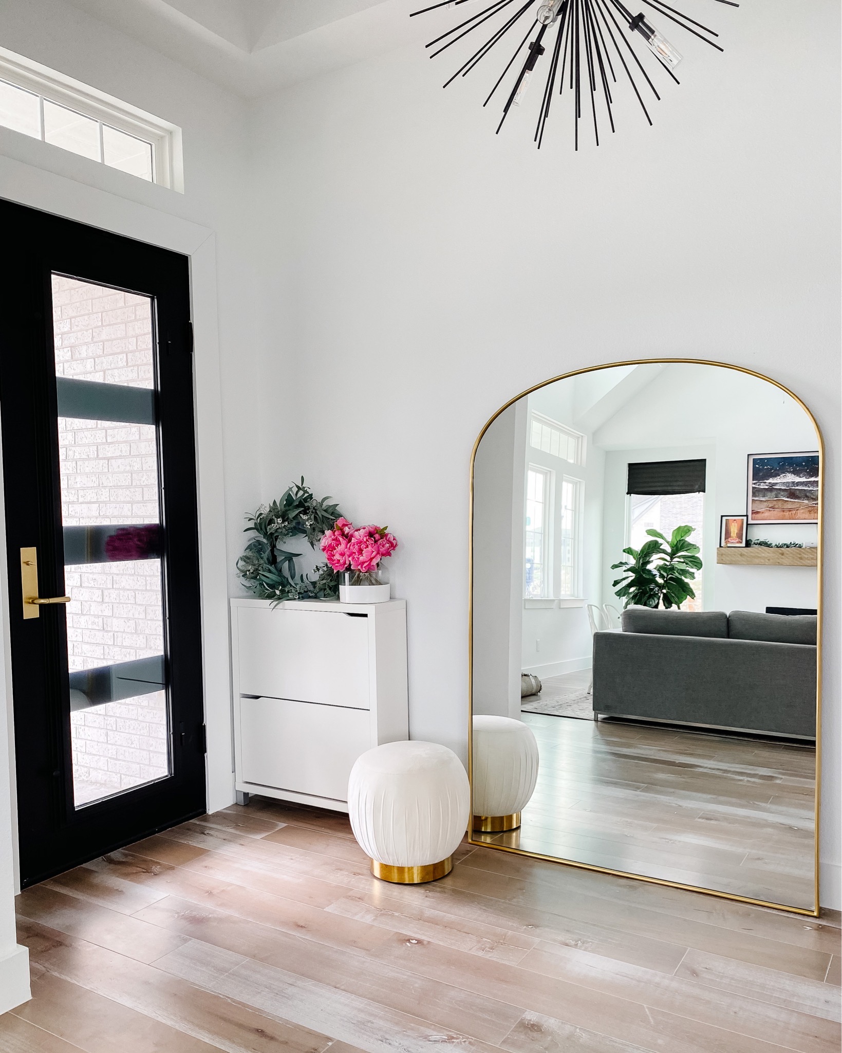 Clean minimal entryway with hidden shoe storage and arched mirror