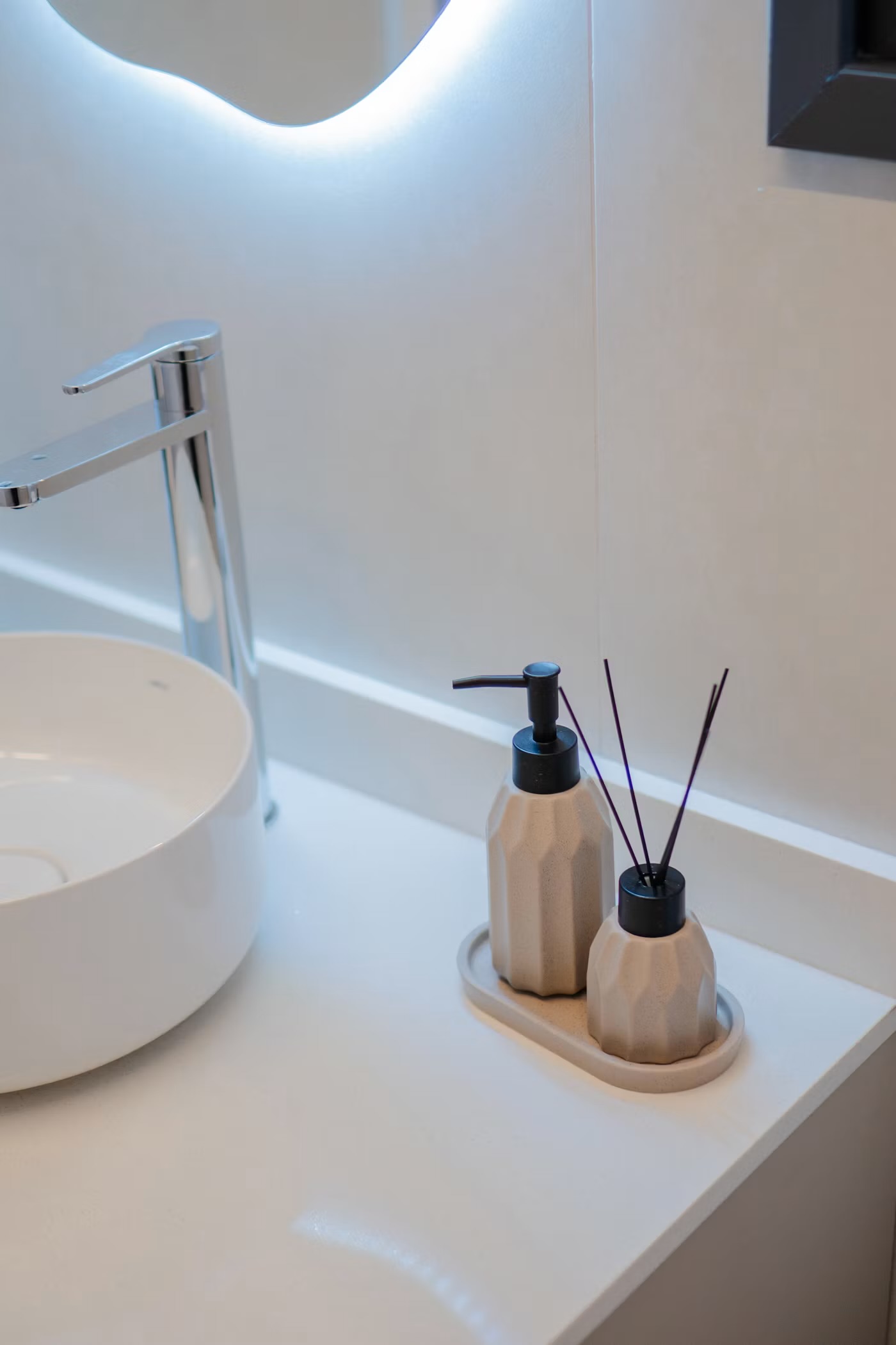 Bathroom counter with matching glass accessories set in warm neutral tones