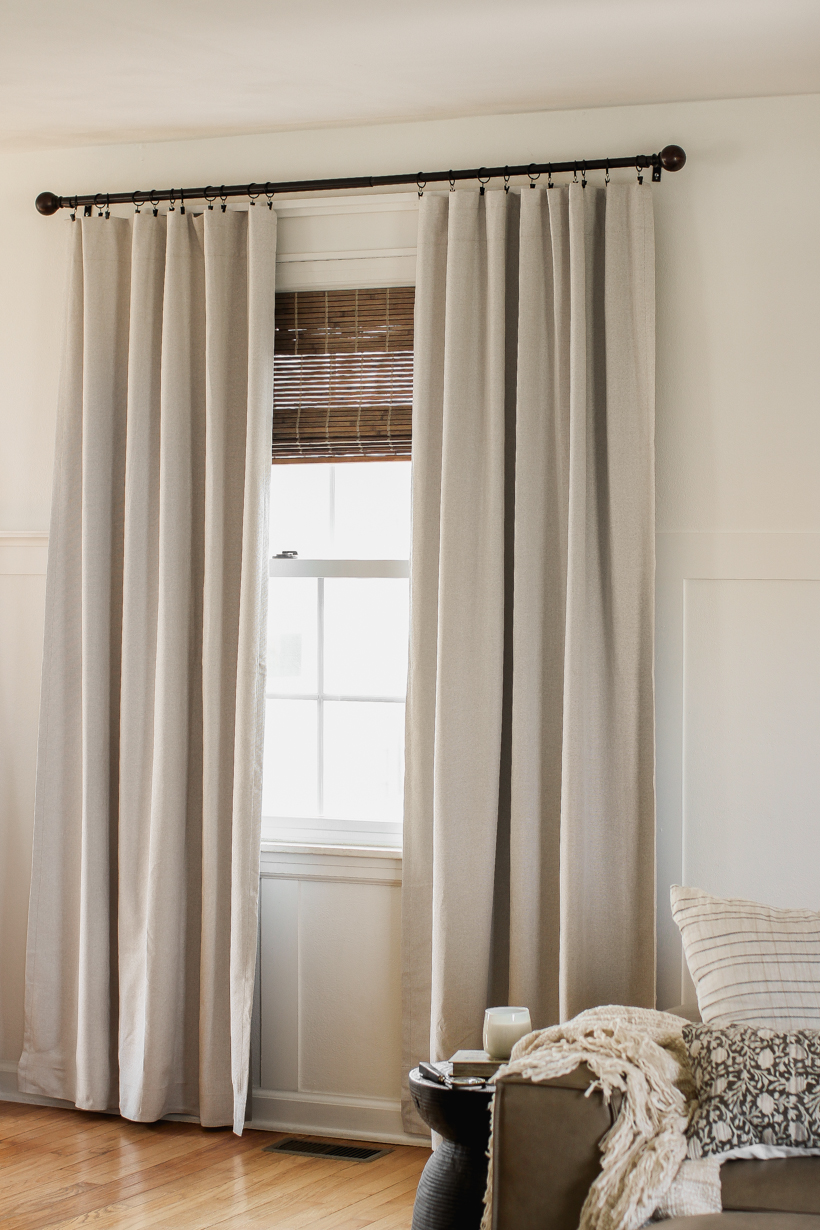 Living room with floor length curtains hung high near the ceiling making the room look taller