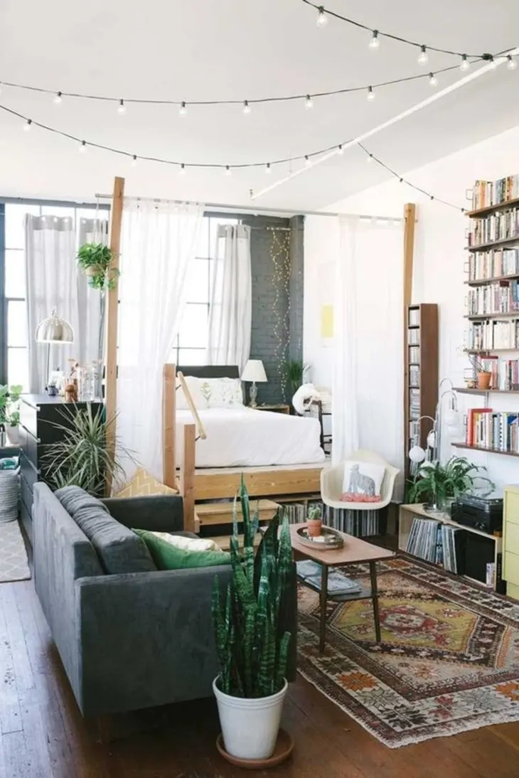 Warm ambient lighting in a small apartment with string lights and a floor lamp creating a cozy atmosphere