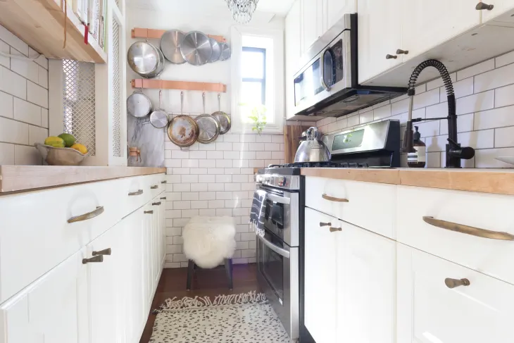 Small rental kitchen with peel and stick backsplash matching storage jars and styled open shelving