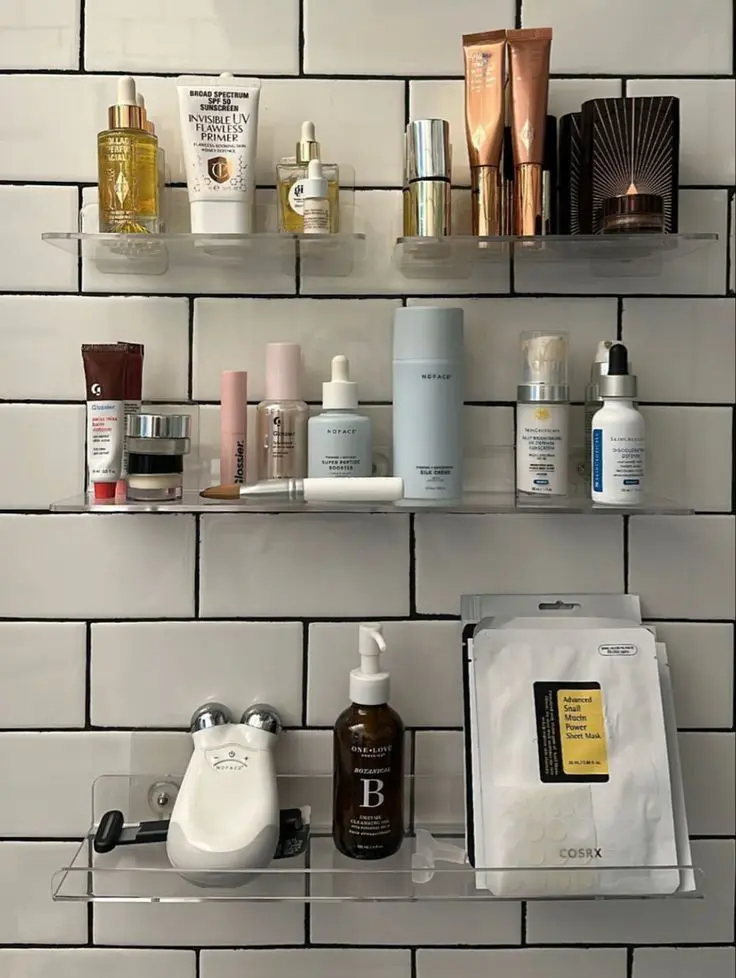 Small bathroom with wall mounted shelves holding skincare and makeup products off the counter