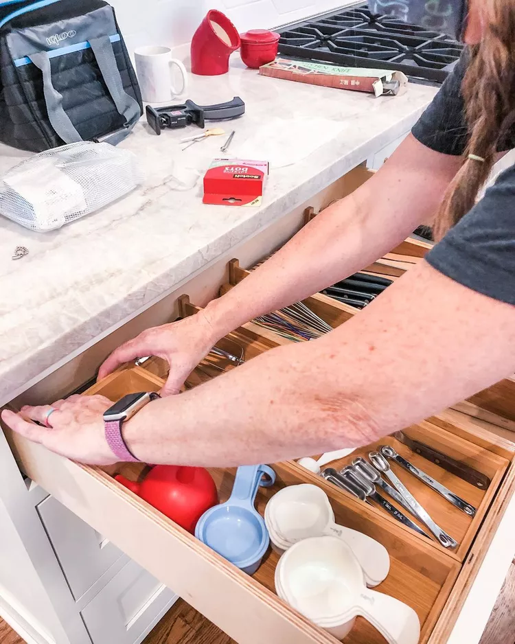 Organized kitchen drawer with adjustable dividers separating utensils and tools