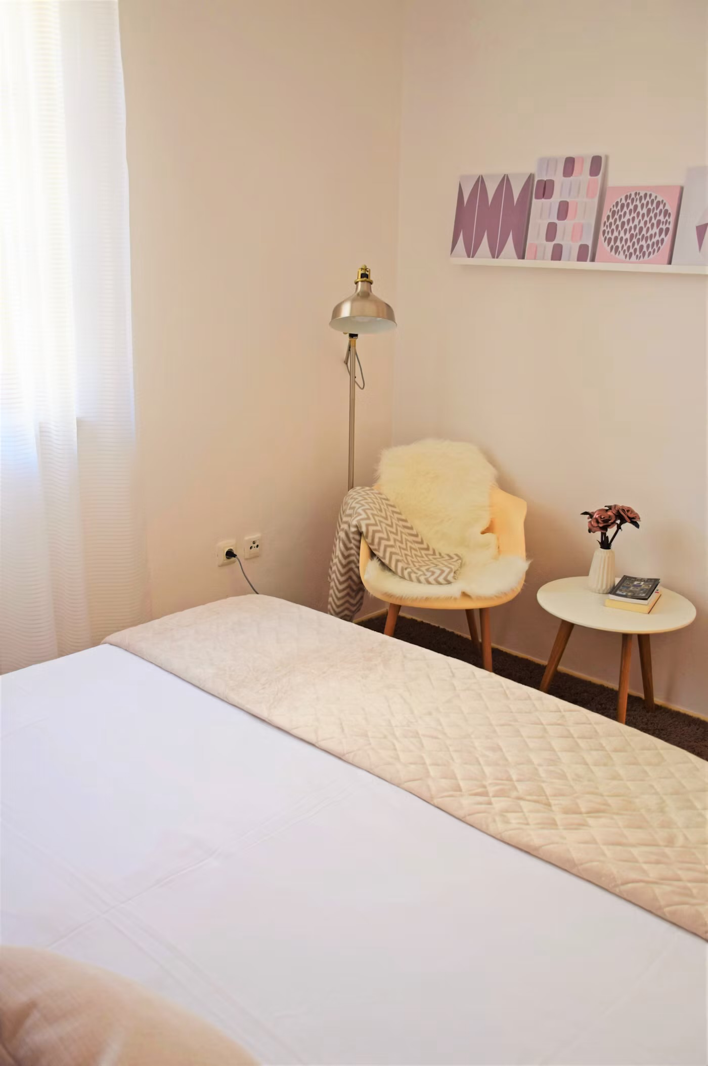 Calm organized small bedroom with neutral bedding and minimal nightstand styling