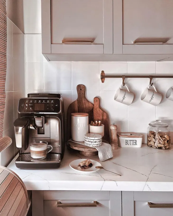 Aesthetic small kitchen coffee bar with compact coffee machine syrups and styled accessories