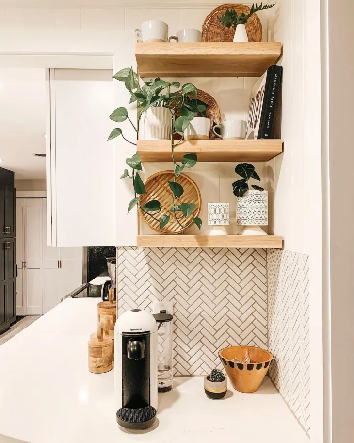 Coffee corner with floating shelves above holding mugs plants and coffee art