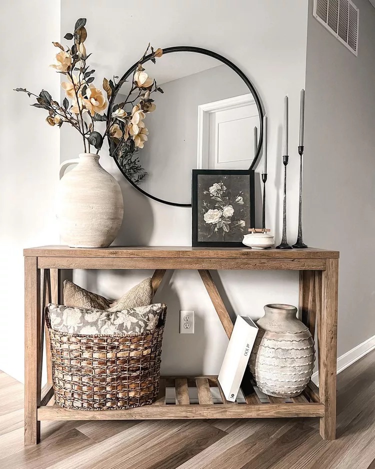 Large ceramic vase with faux stems on a styled entryway console table
