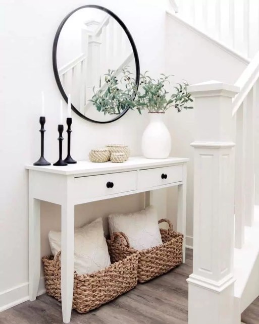 Two candle holders at different heights on an entryway table creating layered elegance